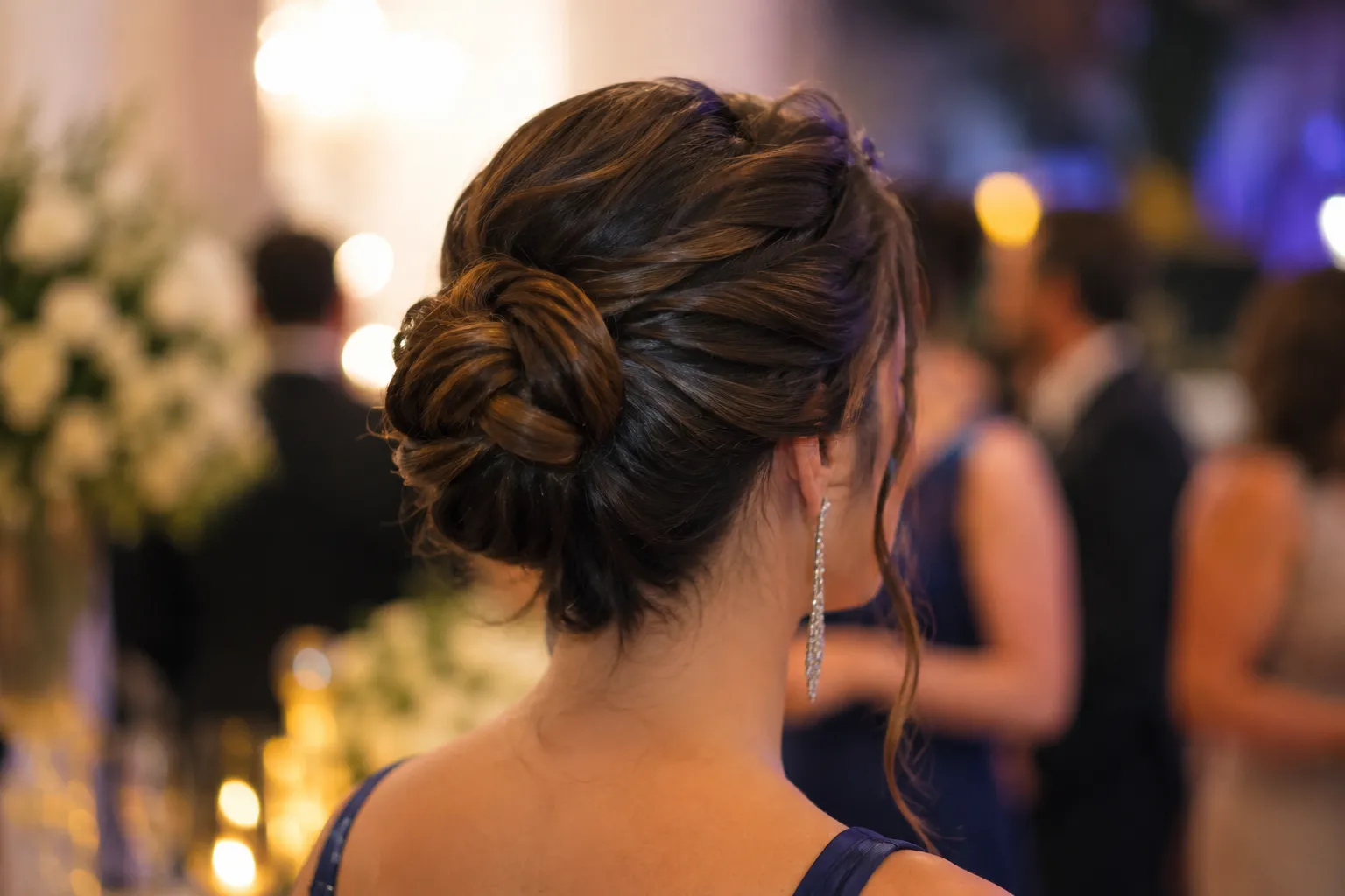 Coque baixo trançado com mechas soltas em festa à noite